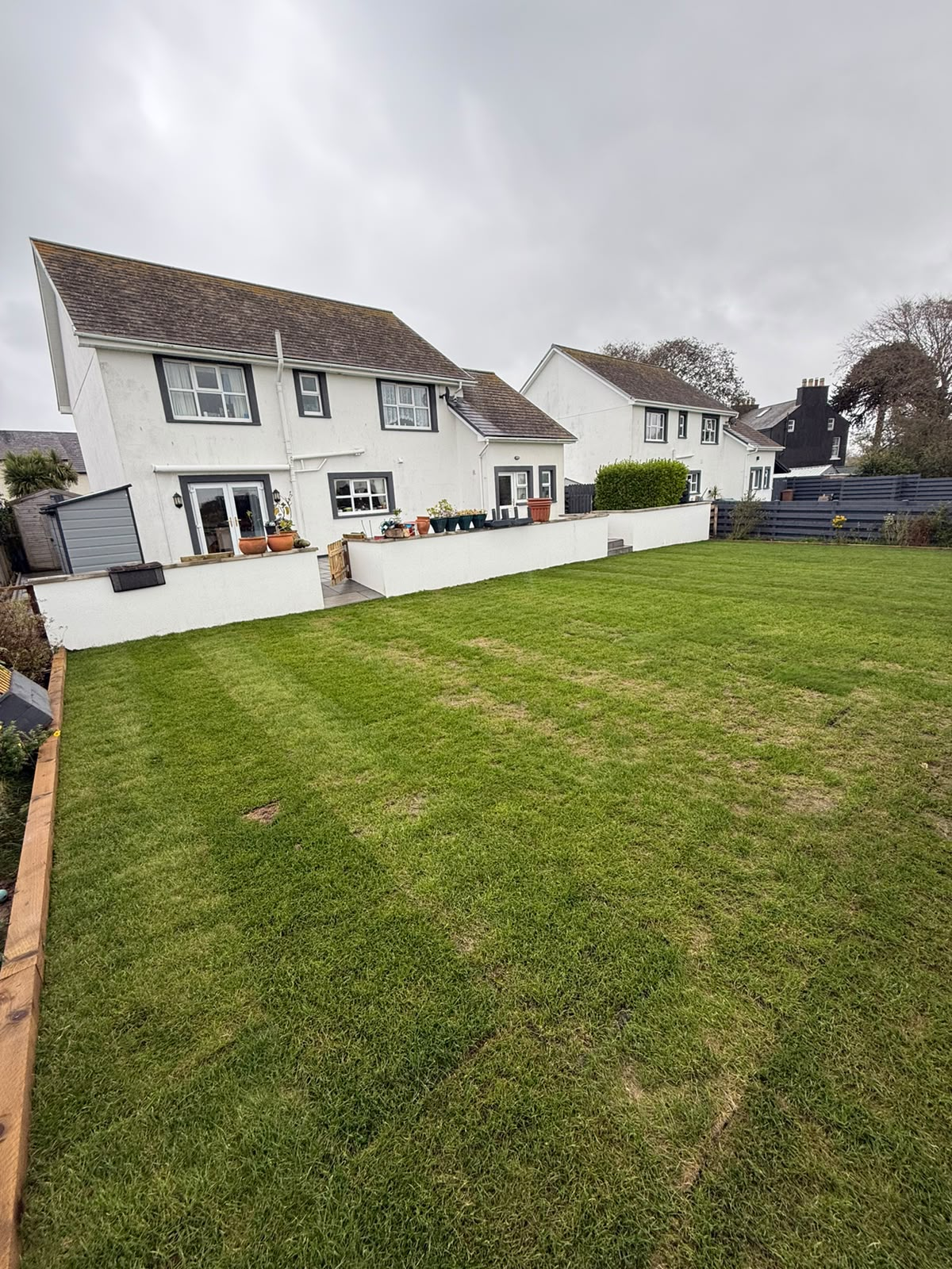 Completed patio and landscaping transformation with new lawn and premium paved terrace, Isle of Man